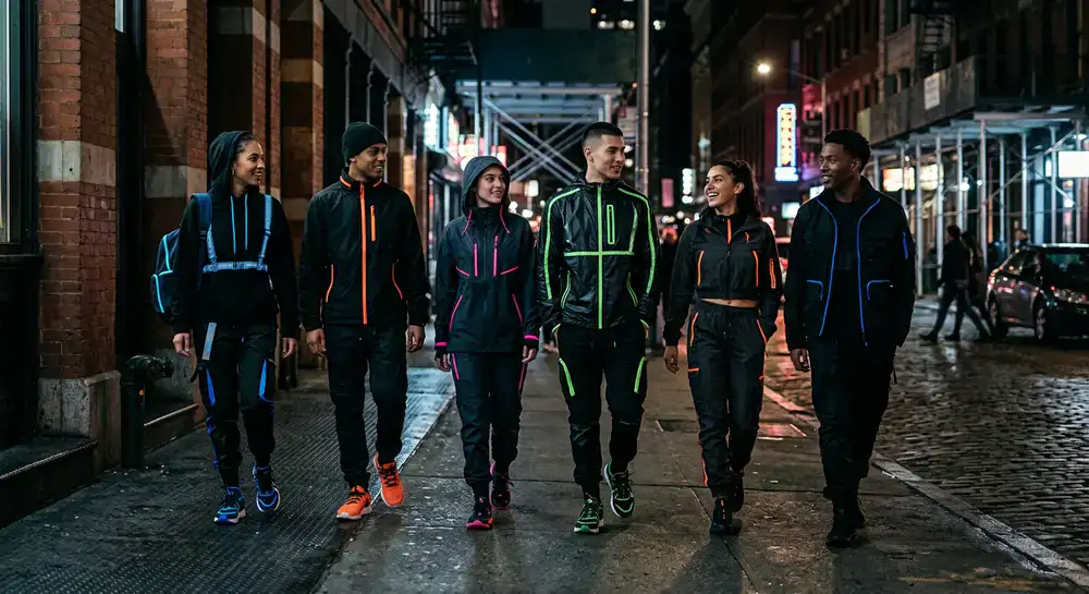 Group of individuals wearing dark streetwear with neon accents